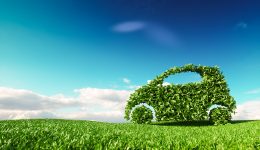 Eco friendly car development, clear ecology driving, no pollution and emmission transportation concept. 3d rendering of green car icon on fresh spring meadow with blue sky in background.